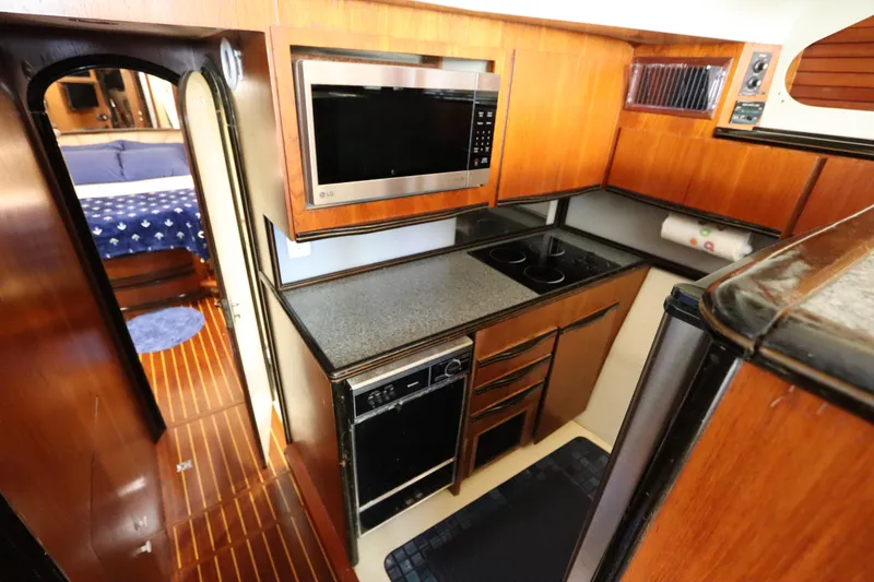 Slide: The Image of Compact kitchen in 1991 Spectrum 48 Convertible yacht with wood cabinetry and modern appliances. - 20