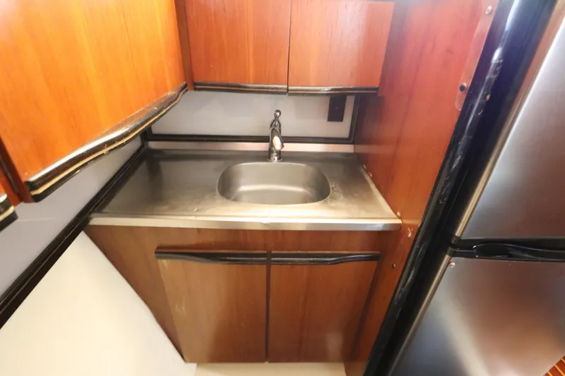 Slide: The Image of 1991 Spectrum 48 Convertible yacht kitchen with stainless steel sink and wooden cabinets. - 24