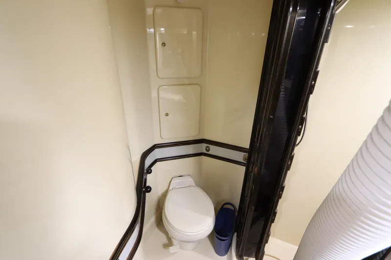 Slide: The Image of 1991 Spectrum 48 Convertible yacht bathroom with toilet and storage compartments. - 39