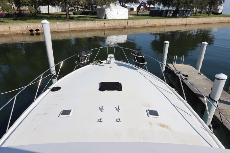 Slide: The Image of Bow view of a 1991 Spectrum 48 Convertible yacht docked at a marina. - 5