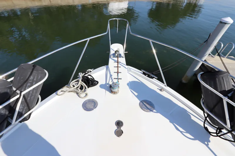 Slide: The Image of Bow of 1991 Spectrum 48 Convertible yacht with ropes and fenders docked at marina. - 6