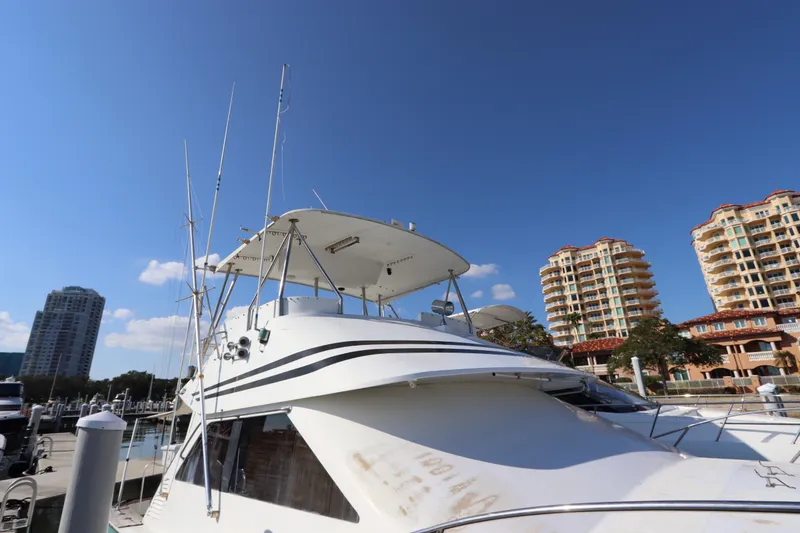 Slide: The Image of 1991 Spectrum 48 Convertible yacht docked near luxury waterfront buildings. - 8