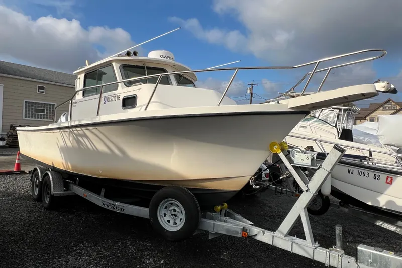The Image of 2001 Parker 2520 Deep Vee Sport Cabin boat on trailer, parked outdoors. - 0