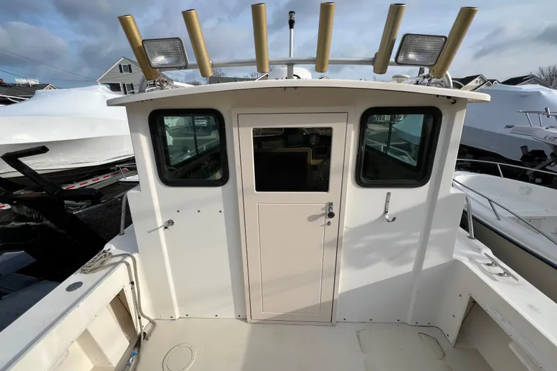 Slide: The Image of 2001 Parker 2520 Deep Vee Sport Cabin boat with fishing rod holders and deck view. - 4