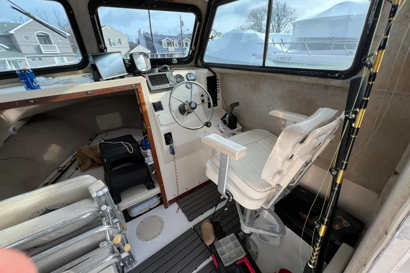 Slide: The Image of 2001 Parker 2520 Deep Vee Sport Cabin interior with steering wheel and captain's chair. - 6