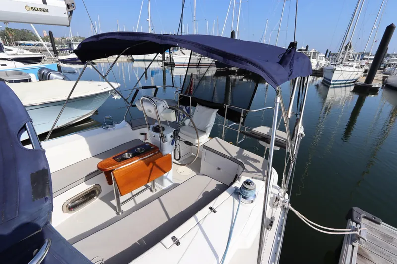 Slide: The Image of Cockpit of 2011 Catalina 355 sailboat docked at marina, featuring blue canopy and wooden table. - 10