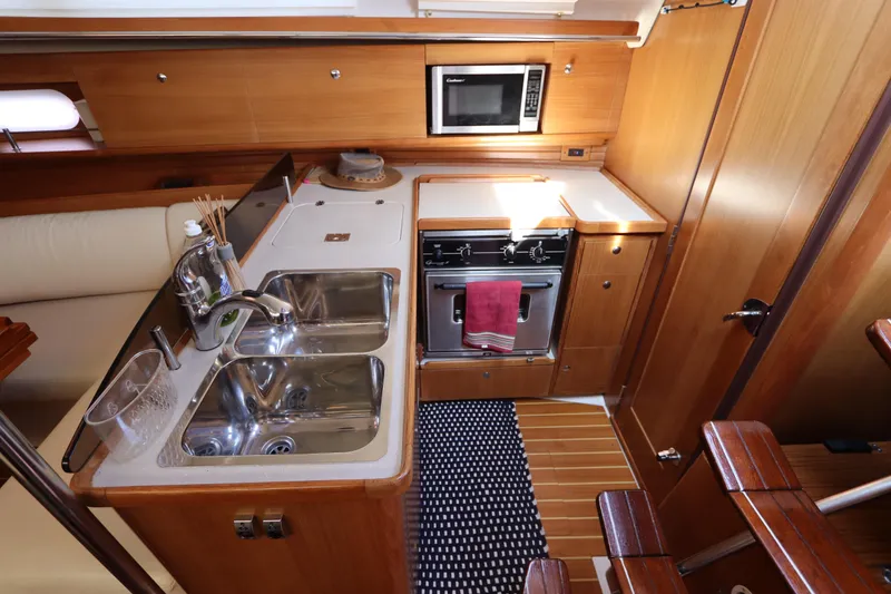 Slide: The Image of Luxurious 2011 Catalina 355 yacht kitchen with modern appliances and wooden cabinetry. - 29