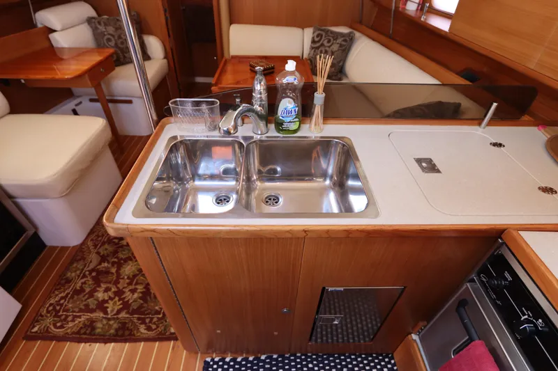 Slide: The Image of Interior of 2011 Catalina 355 yacht kitchen with double sink and wooden cabinetry. - 30