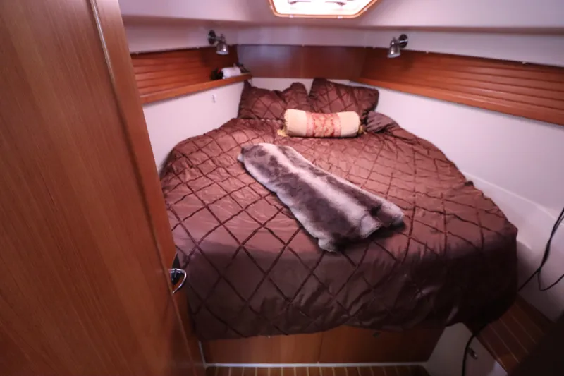 Slide: The Image of Cozy cabin interior of 2011 Catalina 355 sailboat with plush bedding and wood accents. - 48