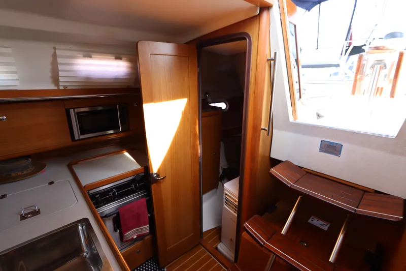 Slide: The Image of Interior of 2011 Catalina 355 sailboat with kitchen and wooden cabinetry. - 53