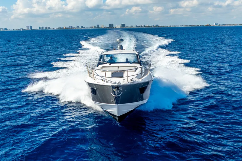 Slide: The Image of 2021 Azimut Atlantis 51 yacht cruising on open blue sea, city skyline in background. - 8