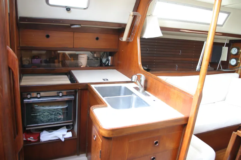 Slide: The Image of Interior of 1983 Beneteau Idylle 11.50 yacht, featuring a compact kitchen area. - 5