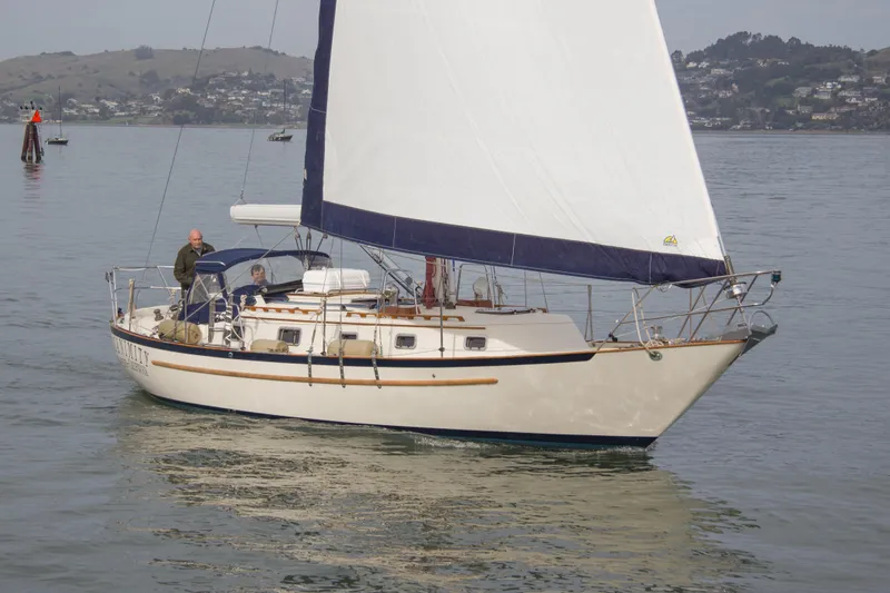 The Image of 1992 Pacific Seacraft 37 sloop sailing on calm waters with scenic background. - 0