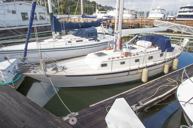 Slide: The Image of 1992 Pacific Seacraft 37 sloop docked at a marina, surrounded by other boats. - 9
