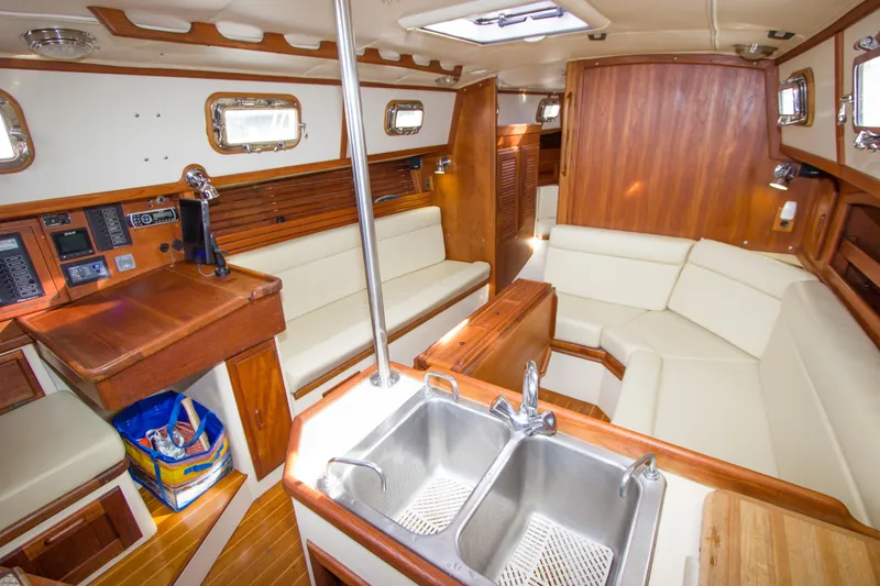 Slide: The Image of Interior of 1992 Pacific Seacraft Cutter yacht with wood finish and white seating. - 12