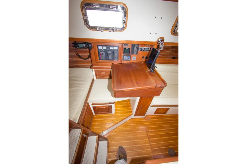 Slide: The Image of 1992 Pacific Seacraft Cutter interior with navigation station and wooden flooring. - 18