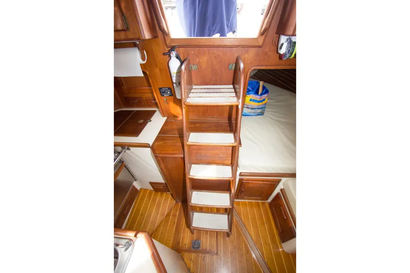 Slide: The Image of Interior of 1992 Pacific Seacraft Cutter with wooden steps and cozy cabin space. - 25