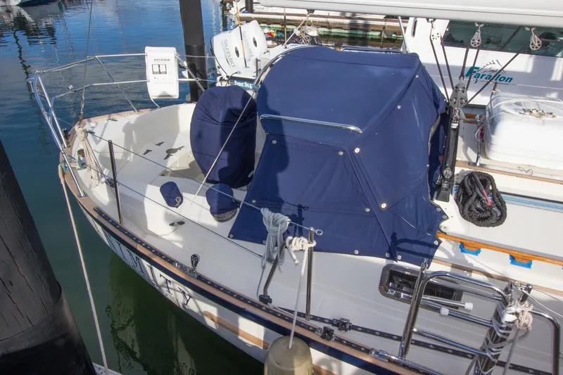Slide: The Image of 1992 Pacific Seacraft 37 sloop with blue canvas cover docked at marina. - 31