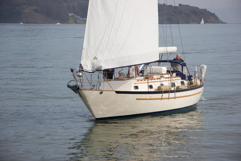 Slide: The Image of 1992 Pacific Seacraft 37 sloop sailing on calm waters with scenic background. - 5