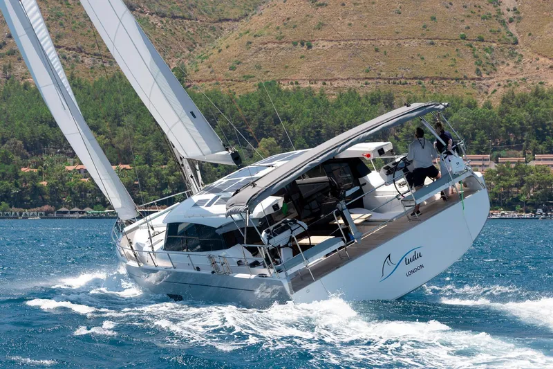 The Image of Sailing yacht Moody 48 deck saloon 2026 navigating through blue waters near a forested coastline. - 0