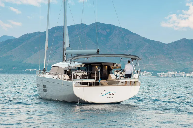 Slide: The Image of 2026 Moody 48 Deck Saloon yacht sailing with mountains in the background. - 12