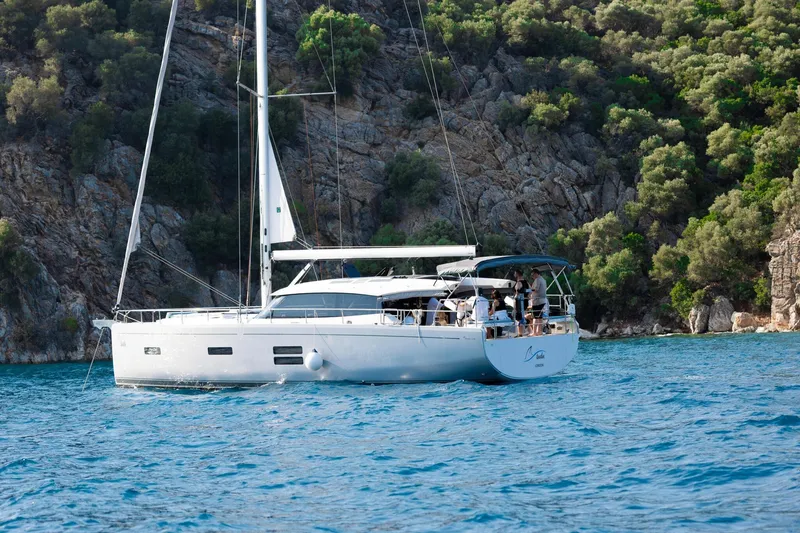 Slide: The Image of Sailing yacht Moody 48 Deck Saloon 2026 cruising near rocky coastline. - 16