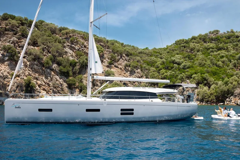 Slide: The Image of 2026 Moody 48 Deck Saloon yacht anchored in scenic coastal waters. - 17