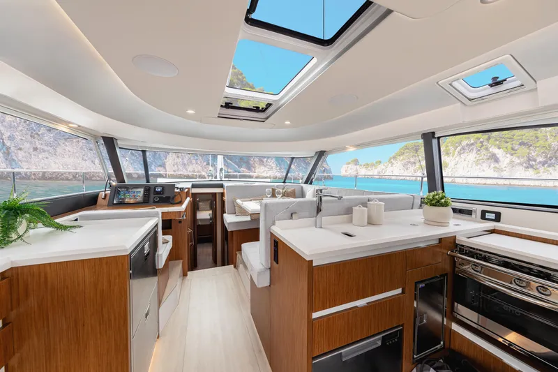 Slide: The Image of Luxurious interior of 2026 Moody 48 Deck Saloon yacht with modern kitchen and scenic views. - 22