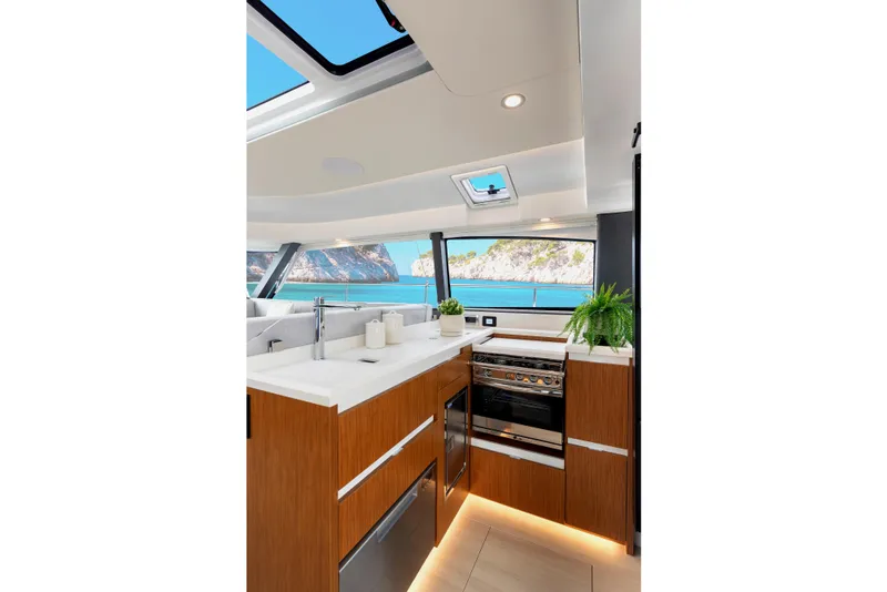 Slide: The Image of Luxurious interior of 2026 Moody 48 Deck Saloon yacht with modern kitchen and scenic ocean view. - 25