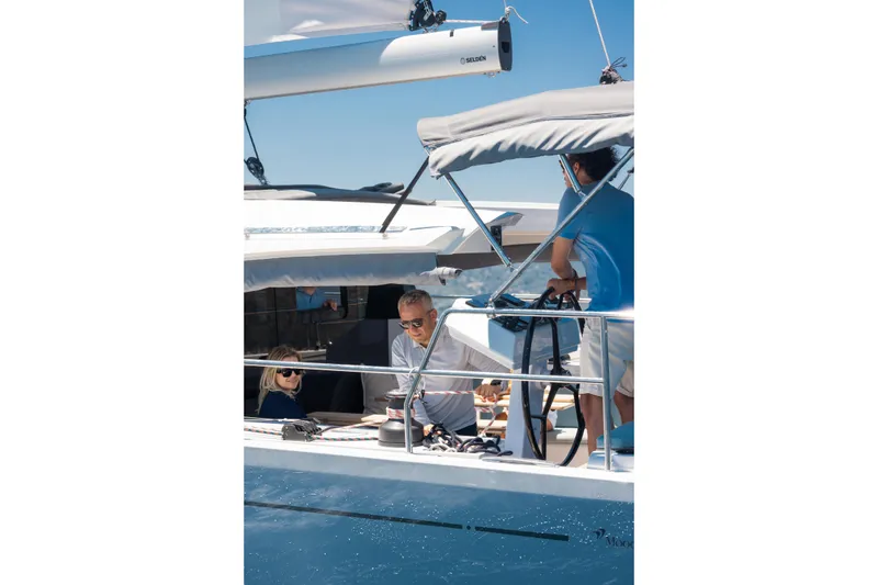 Slide: The Image of 2026 Moody 48 Deck Saloon yacht with people enjoying a sunny day at sea. - 7