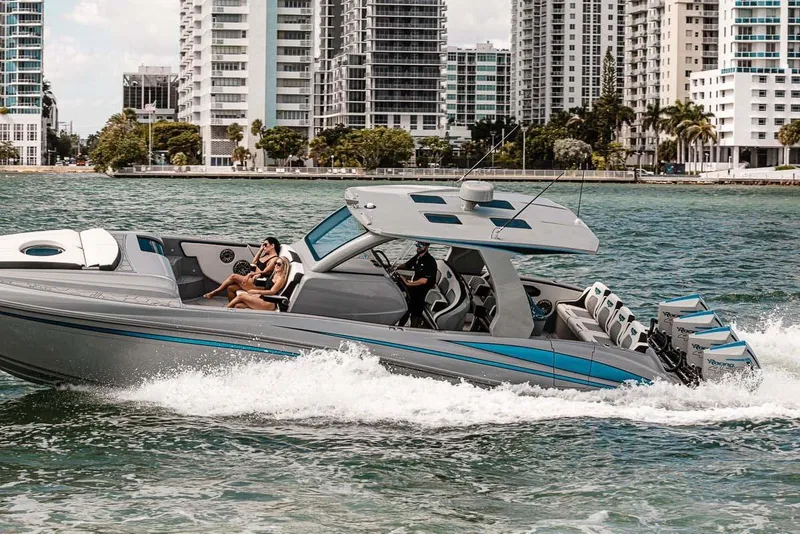 Slide: The Image of 2027 Deep Impact 399 Fwd Cabin cruising near city skyline, featuring sleek design and powerful engines. - 2