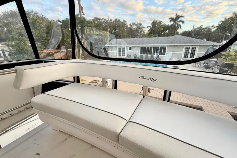 Slide: The Image of 1999 Sea Ray 560 Sedan Bridge interior with white seating and scenic window view. - 10