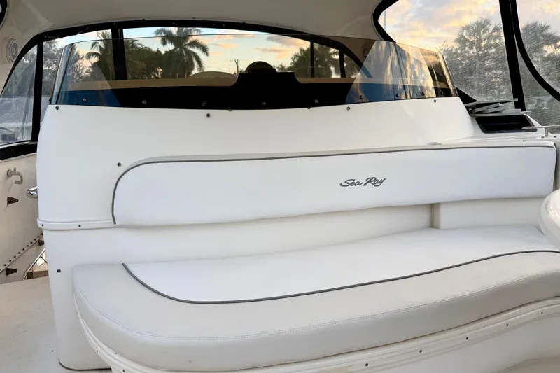 Slide: The Image of 1999 Sea Ray 560 Sedan Bridge interior with white seating and scenic window view. - 12