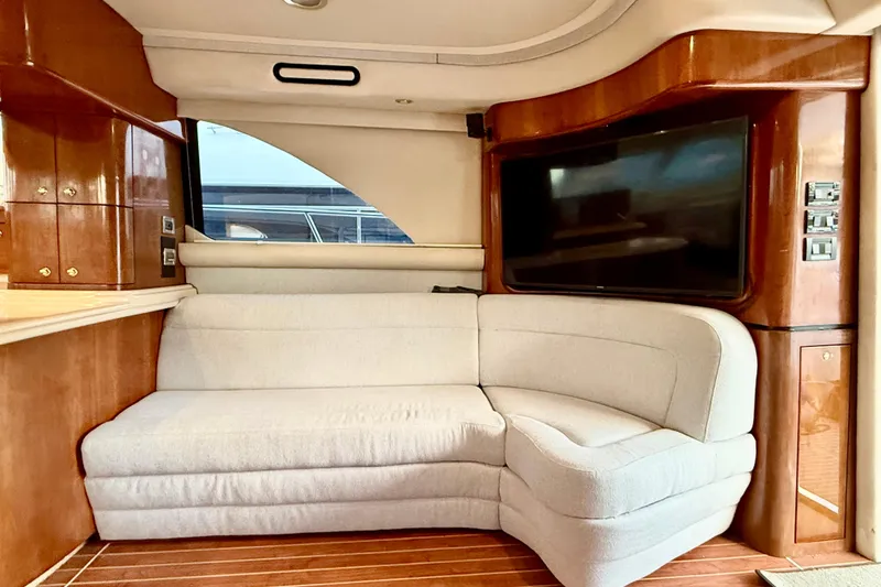 Slide: The Image of Luxurious interior of 1999 Sea Ray 560 Sedan Bridge yacht with plush seating and wood finishes. - 15