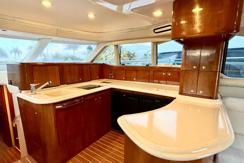 Slide: The Image of Luxurious 1999 Sea Ray 560 Sedan Bridge yacht kitchen with elegant wood cabinetry and modern fixtures. - 16