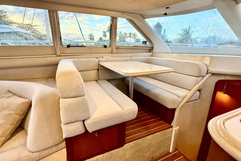 Slide: The Image of Interior of 1999 Sea Ray 560 Sedan Bridge with cozy dining area and scenic window view. - 17