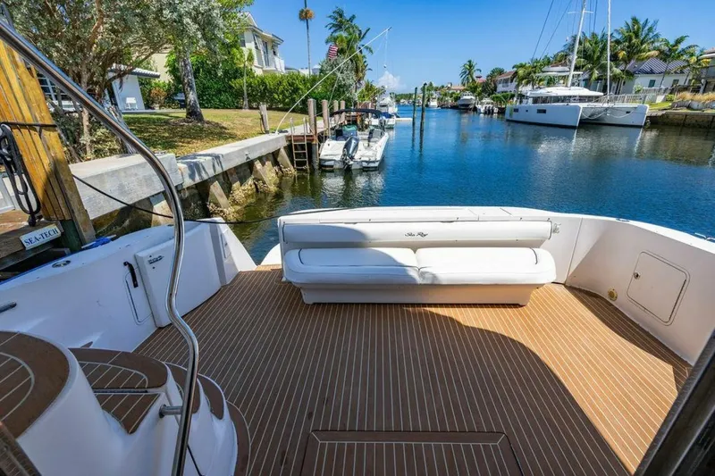 Slide: The Image of 1999 Sea Ray 560 Sedan Bridge yacht on calm water, surrounded by palm trees. - 2