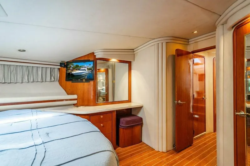 Slide: The Image of 1999 Sea Ray 560 Sedan Bridge yacht cruising on a sunny day with palm trees in the background. - 4