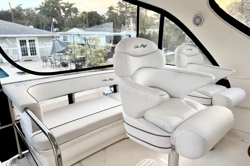 Slide: The Image of 1999 Sea Ray 560 Sedan Bridge interior with white leather seating and panoramic windows. - 9