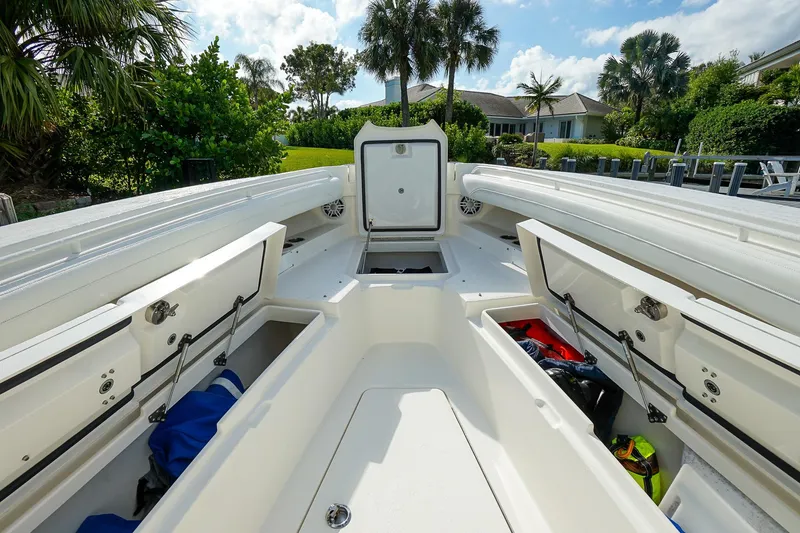 Slide: The Image of 2021 Regulator 31 boat interior with open storage compartments, surrounded by lush greenery. - 13