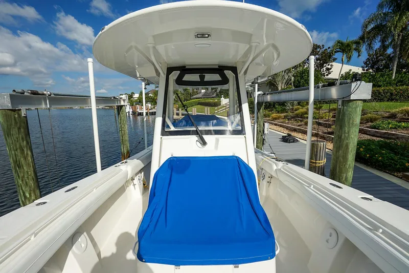 Slide: The Image of 2021 Regulator 31 boat docked, featuring a blue seat and clear skies. - 18