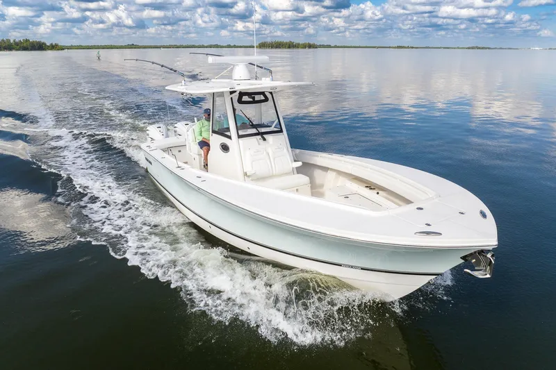 Slide: The Image of 2021 Regulator 31 boat cruising on calm water under a partly cloudy sky. - 2