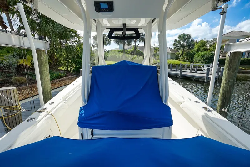 Slide: The Image of 2021 Regulator 31 boat with blue covers docked by a scenic waterfront. - 20