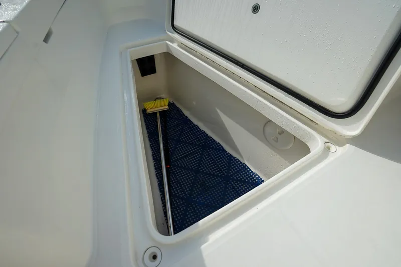 Slide: The Image of Storage compartment on 2021 Regulator 31 boat with cleaning brush inside. - 23