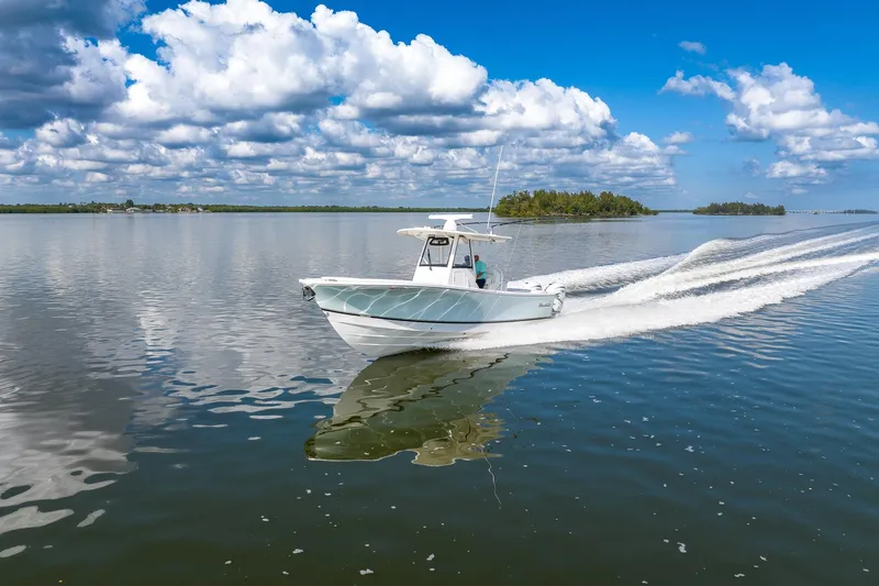 Slide: The Image of 2021 Regulator 31 boat cruising on calm water under a partly cloudy sky. - 3