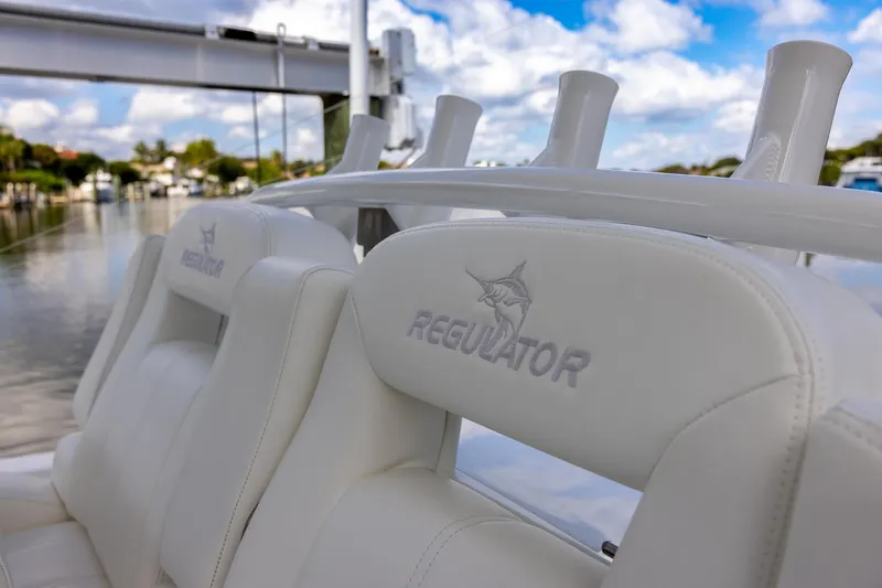 Slide: The Image of 2021 Regulator 31 boat with white leather seats and logo, under a blue sky. - 30