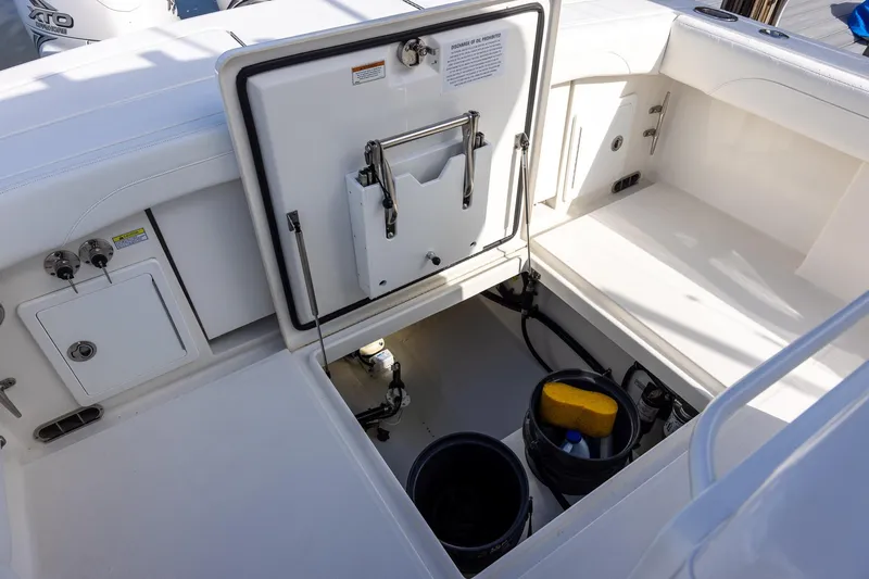 Slide: The Image of 2021 Regulator 31 boat storage compartment with open hatch and cleaning supplies. - 35