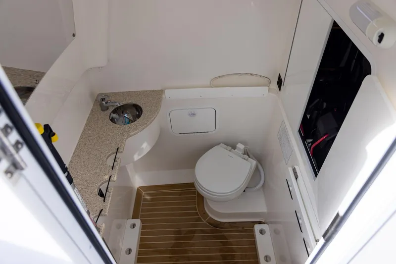 Slide: The Image of 2021 Regulator 31 boat interior with compact bathroom, featuring a toilet and sink. - 39