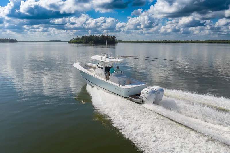 Slide: The Image of 2021 Regulator 31 boat cruising on calm water under a partly cloudy sky. - 4