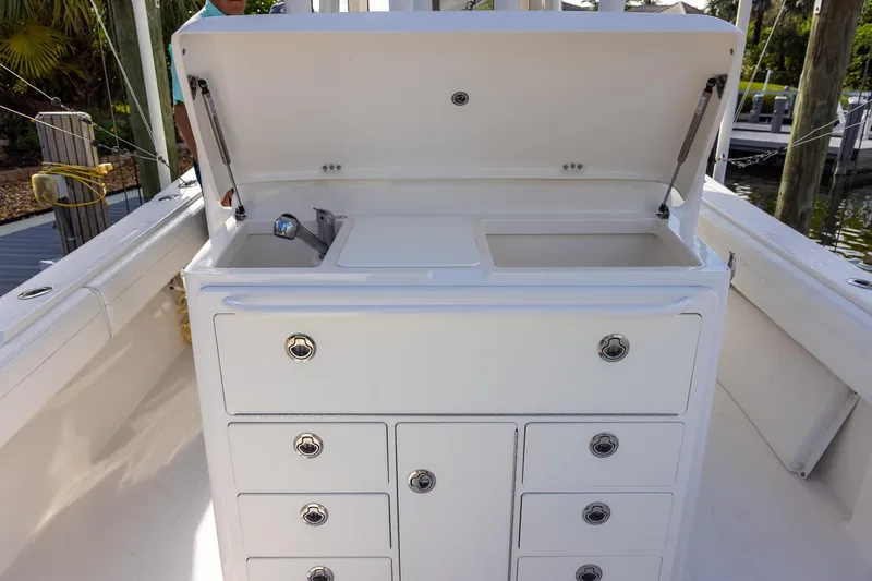 Slide: The Image of 2021 Regulator 31 boat with open storage compartment and sink on deck. - 44